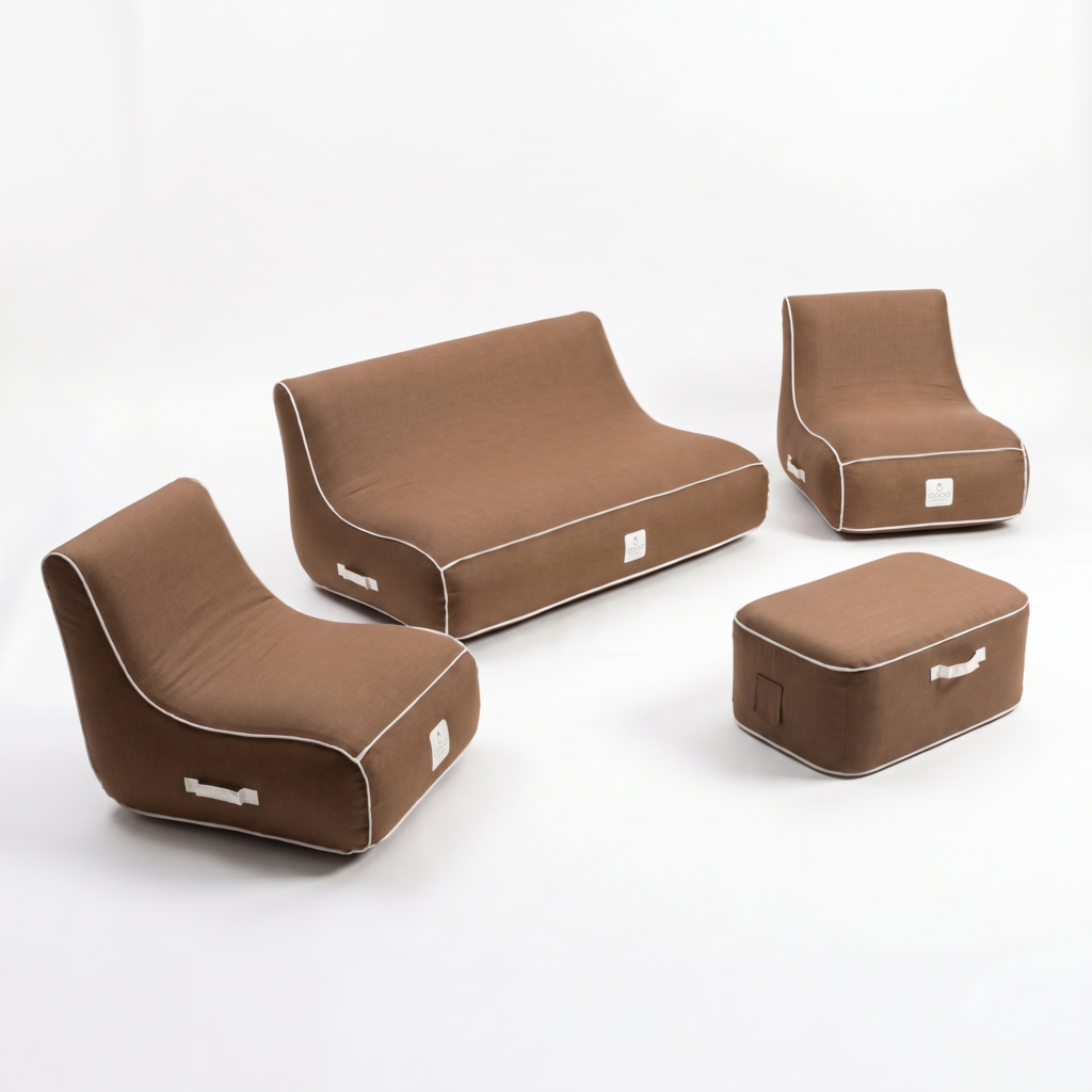 Ensemble de mobilier gonflable marron avec passepoil blanc comprenant un canapé deux places, deux fauteuils et un pouf, photographié sur fond blanc avec poignées de transport apparentes