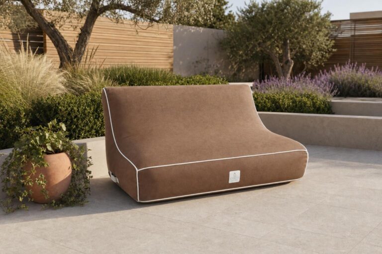 Canapé gonflable deux places marron taupe avec liseré blanc en tissu Olefin mat, installé dans un jardin contemporain sous une lumière naturelle douce.