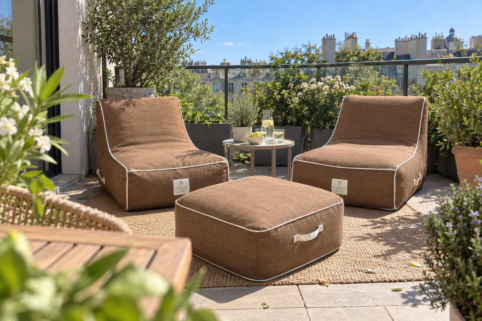 Deux fauteuils et le pouf gonflables Coco Lounge chocolat sur une petite terrasse en ville