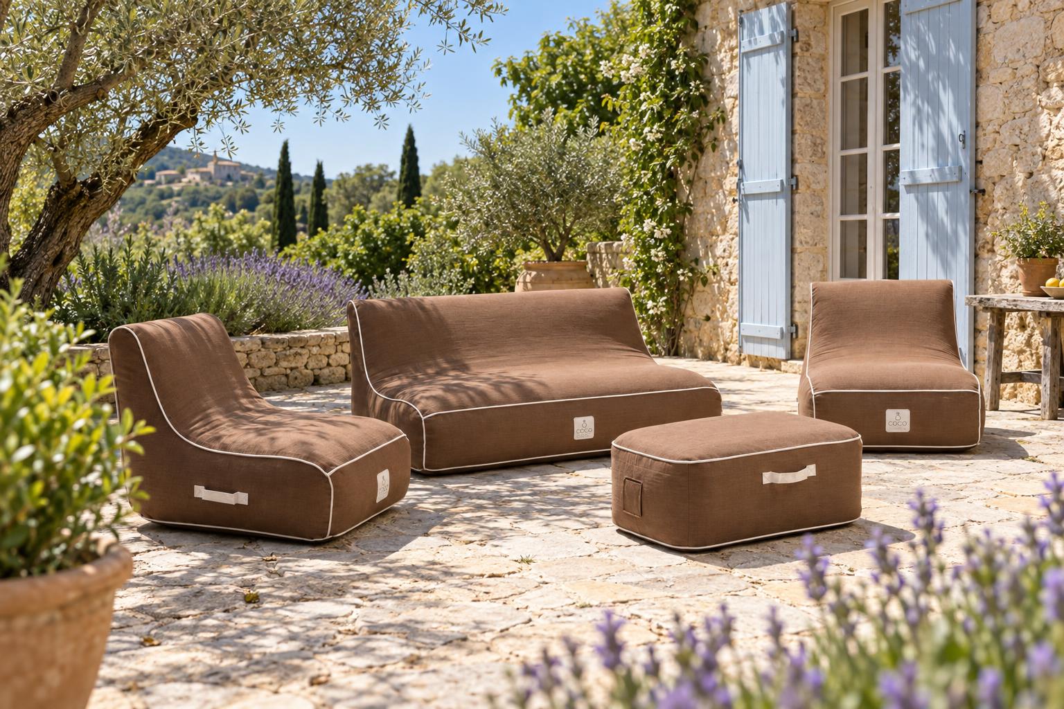 Salon de jardin gonflable Coco Lounge chocolat sur la terrasse en pierre d'un mas provençal, oliviers et lavande